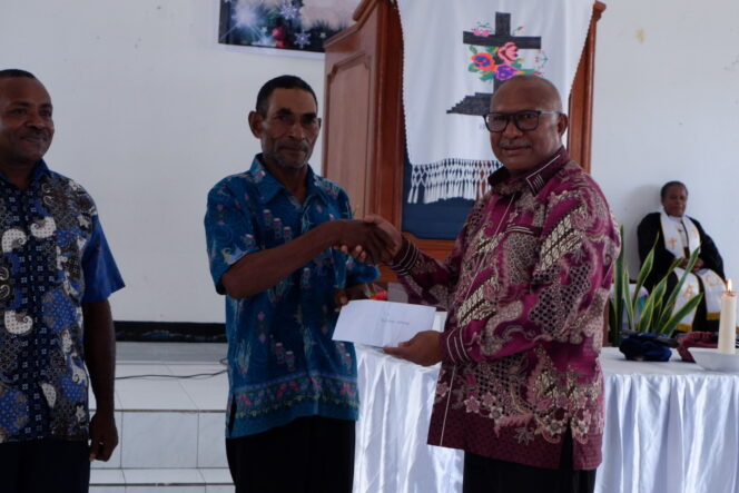 
					Penjabat Bupati Kepulauan Yapen, Welliam Manderi saat menyerahkan hadiah saat ibadah syukur di GKI Pniel Dawai, Minggu 14 Januari 2024. (KabarPapua,co/Ainun Faathirjal)