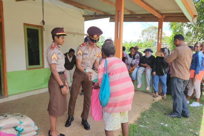 
					Dua Taruna Akpol kelahiran Merauke berbagi kasih dengan warga Papua di Distrik Kurik, Merauke. (KabarPapua.co/Abdel Syah)