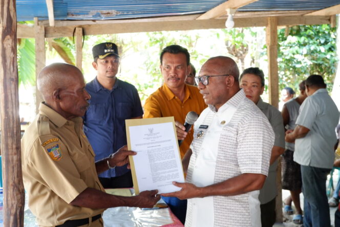 
					Penjabat Bupati Kepulauan Yapen, Welliam Manderi menyerahkan SK Pengaktifan Kepala Kampung Turu, Kostan Barangkea. (KabarPapua.co/Ainun  Faathirjal)