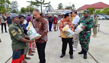 Penjabat Gubernur Papua Pegunungan, Velix Vernando Wanggai menyerahkan simbolis paket bantuan pangan beras di Kabupaten Jayawijaya, Jumat 23 Februari 2024. (KabarPapua.co/Stefanus Tarsi)