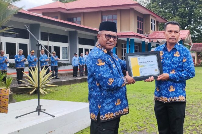 
					Pj Bupati Kepulauan Yapen Welliam Manderi menyerahkan penghargaan wajib pajak kepada Kadis DPMK Jan Lermatan, Selasa 21 Mei 2024. (KabarPapua.co/Ainun Faathirjal)