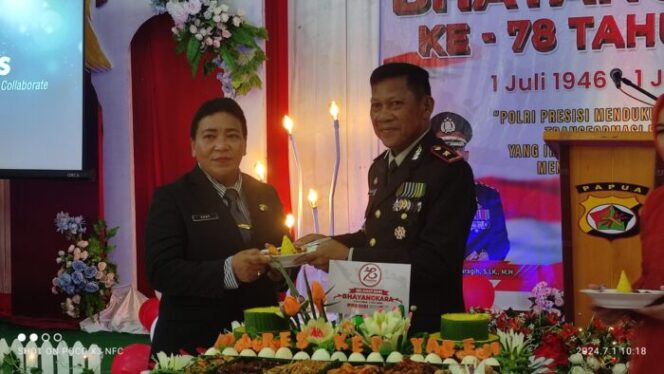 
					Sekda Kepulauan Yapen Erny Tania menerima potongan nasi tumpeng HUT Bhayangkara dari Wakapolres Kompol Nursalam Saka, Senin 1 Juli 2024. (KabarPapua.co/Ainun Faathirjal)
