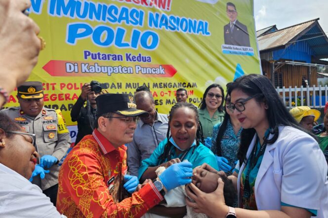 
					Penjabat Bupati Puncak Darwin Tobing meneteskan vaksin polio pada anak di Puskemas Ilaga, 4 Juli 2024. (Diskominfo Puncak)