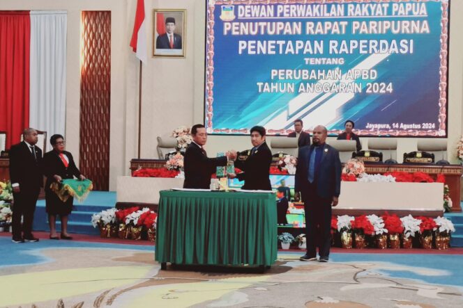 
					Ketua DPR Papua, Jhony Banua Rouw menyerahkan hasil sidang kepada PJ Gubernur Papua, Mayjen (Purn) Ramses Limbong. (KabarPapua.co/Imelda)