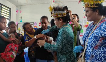 Penjabat Ketua TP PKK Papua, Kerdina Ramses Limbong saat memberikan imunisasi polio di Kepulauan Yapen. (KabarPapua.co/Ainun Faathirjal)