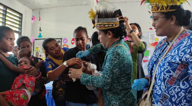 Penjabat Ketua TP PKK Papua, Kerdina Ramses Limbong saat memberikan imunisasi polio di Kepulauan Yapen. (KabarPapua.co/Ainun Faathirjal)