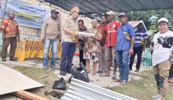 Ketua DPR Papua Jhony Banua Rouw saat menyerahkan bantuan bahan bangunan secara simbolis kepada warga setempat. (Dok Imelda)