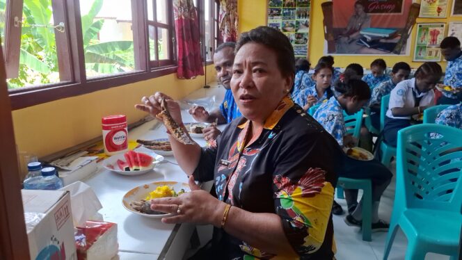 
					Sekda Yapen Erny Tania saat menikmati ikan lele goreng hasil budidaya siswa SMPN Anotourei. (KabarPapua.co/Ainun Faathirjal)