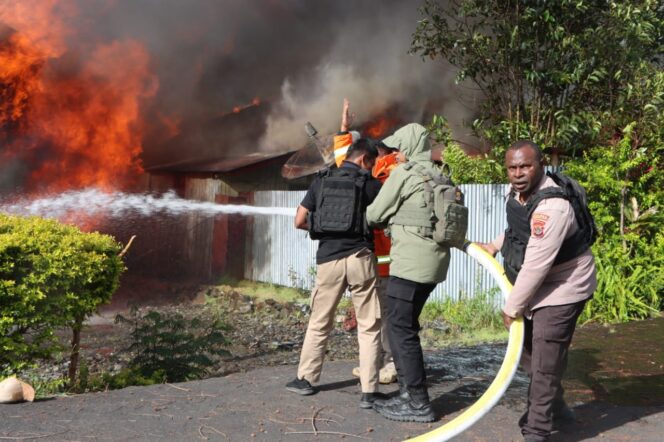 
					Polisi berusaha memadamkan api yang membakar rumah warga di Puncak Jaya. Foto: Polda Papua.