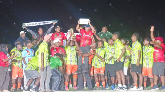 
					Persigubin bersama Bupati Spey Yan Bidana saat menerima trofi kemenangan. (KabarPapua.co/Agris Wistrijaya)