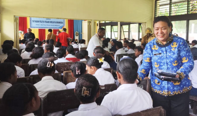
					Sekda Kepulauan Yapen Erny Renny Tania saat membagikan makanan saat launching SPPG di SMP Menawi. (KabarPapua.co/Ainun Faathirjal)