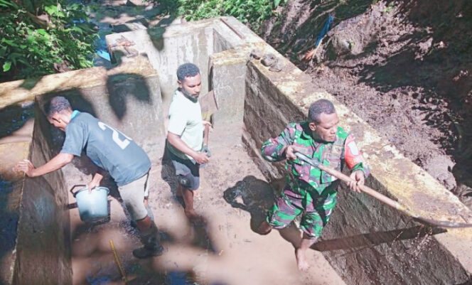 
					Pembersihan bak penampungan air bersih Kampung Manaini. (Foto dok: Kodim 1709/Yawa)
