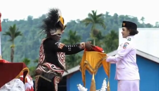 
					Penyerahan bendera Merah Putih oleh Gubernur Papua Tengah, Meki Nawipa pada HUT ke 80 RI. Foto: scereenshot