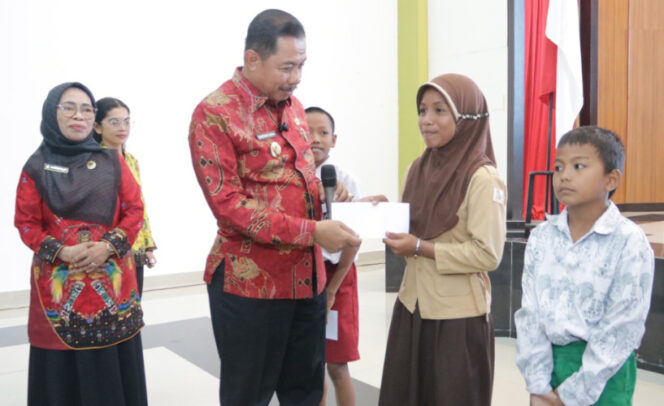 
					Wakil Wali Kota Jayapura Rustan Saru saat serahkan bantuan bagi pelajar penerima manfaat dari Baznas Kota Jayapura. (Foto dok: Prokopim Kota Jayapura)