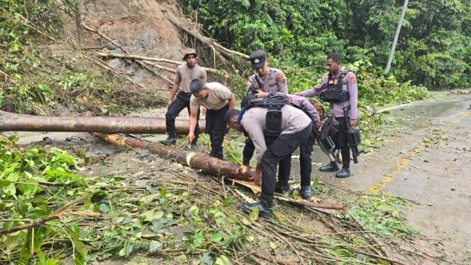 
					Personel Polres Keerom membersihkan material longsor di ruas jalan utama KM 76 Distrik Waris, Kabupaten Keerom, Papua. Foto: Humas Polda Papua. 