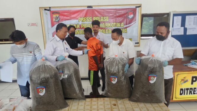 
					MA (baju orange) WNA Papua Nugini yang memiliki ganja seberat 21 kilogram. Foto: Imelda/Kabarpapua.co