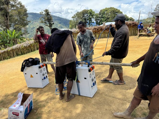 
					Dengan penuh semangat gotong royong, petugas PLN dan warga bahu-membahu memikul panel surya menuju lokasi pemasangan di sekolah-sekolah. Foto: PLN Papua dan Papua Barat