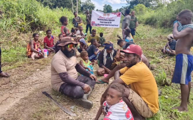 
					Kapospol Yamor, Bripka. Marthen Wayoi (duduk baju coklat) bersama masyarakat saat kerja Bhakti, Senin 1 Desember 2025. (IST)