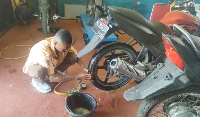 
					Salah satu siswa jurusan otomotif perbengkelan di SMKN 1 Agribisnis dan Agroteknologi Serui sedang memperbaiki kendaraan roda dua. (KabarPapua.co/Ainun Faathirjal)
