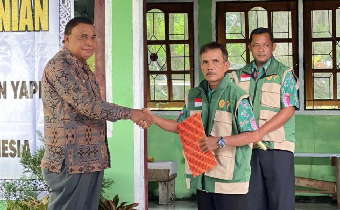 
					Bupati Kepulauan Yapen Benyamin Arisoy menyerahkan SK kepada perwakilan penyuluh pertanian dalam acara peralihan ASN ke Kementan RI. (KabarPapua.co/Ainun Faathirjal)