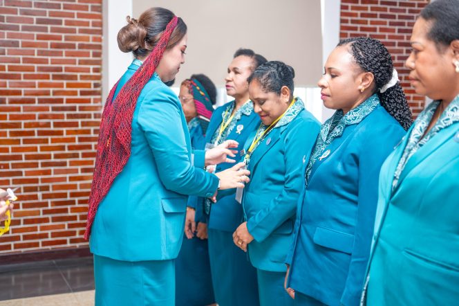 
					Ketua TP PKK Provinsi Papua Pegunungan Ny. Anggieta Bestari Tabo saat memasangkan kartu peserta rakorda. Foto:  Pemprov Papua Pegunungan
