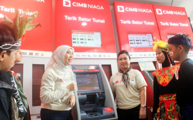 
					Head of Region Jakarta CIMB Niaga Adeline Hendarto (ketiga kanan) bersama  Community Development Head CIMB Niaga Astrid Candrasari (ketiga kiri) memperkenalkan fungsi mesin ATM kepada para peserta kegiatan Tour de Bank. (Foto dok: CIMB Niaga)