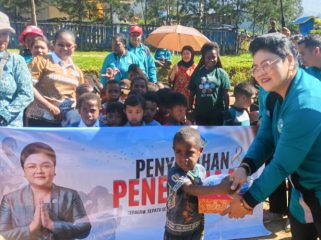 Ketua TP-PKK sekaligus Bunda PAUD Kabupaten Puncak Sujatinah Elvis Tabuni, menyerahkan bantuan ke siswa SD Pemulihan Cartenz Kago dan TK Negeri Ilaga. (Foto dok: Diskominfo Puncak)