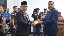 Bupati Kepulauan Yapen Benyamin Arisoy menyerahkan surat keputusan kepada Cyfrianus Y. Mambay usai pelantikan sebagai Penjabat Sekda Kepulauan Yapen. (KabarPapua.co/Ainun Faathirjal)
