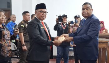Bupati Kepulauan Yapen Benyamin Arisoy menyerahkan surat keputusan kepada Cyfrianus Y. Mambay usai pelantikan sebagai Penjabat Sekda Kepulauan Yapen. (KabarPapua.co/Ainun Faathirjal)

