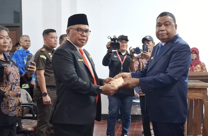 
					Bupati Kepulauan Yapen Benyamin Arisoy menyerahkan surat keputusan kepada Cyfrianus Y. Mambay usai pelantikan sebagai Penjabat Sekda Kepulauan Yapen. (KabarPapua.co/Ainun Faathirjal)
