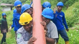 Tim PLN bergotong royong memikul tiang listrik melintasi medan yang menantang di Kampung Sum, Kabupaten Fakfak. (Foto dok: PLN UIW Papua dan Papua Barat) 