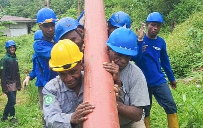 
					Tim PLN bergotong royong memikul tiang listrik melintasi medan yang menantang di Kampung Sum, Kabupaten Fakfak. (Foto dok: PLN UIW Papua dan Papua Barat) 