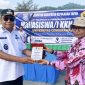 Bupati Kepulauan Yapen Benyamin Arisoy menyerahkan plakat kepada perwakilan Uncen pada pelepasan mahasiswa KKN di Pelabuhan Serui. (KabarPapua.co/Ainun Faathirjal)