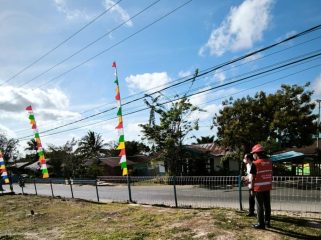 Petugas PLN mengingatkan pentingnya memperhatikan jarak aman saat memasang bendera dan atribut kemerdekaan di sekitar jaringan listrik. Foto:  PLN Papua 