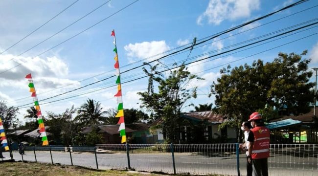 Petugas PLN mengingatkan pentingnya memperhatikan jarak aman saat memasang bendera dan atribut kemerdekaan di sekitar jaringan listrik. Foto:  PLN Papua 