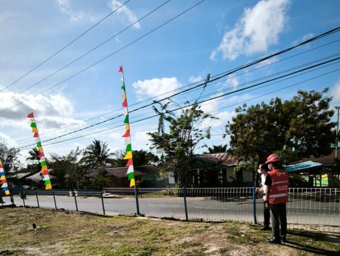 
					Petugas PLN mengingatkan pentingnya memperhatikan jarak aman saat memasang bendera dan atribut kemerdekaan di sekitar jaringan listrik. Foto:  PLN Papua 