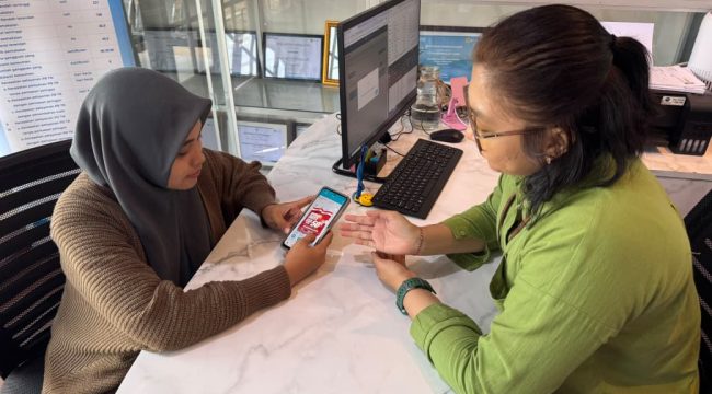 Pegawai PLN memberikan pendampingan kepada pelanggan dalam memanfaatkan promo “Merdeka Daya” melalui aplikasi PLN Mobile untuk mendapatkan diskon tambah daya listrik 50%. Foto:PLN Papua 