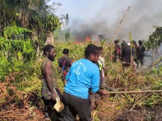 Warga di sekitar Ilaga berusaha memadamkan kobaran api. Foto: Diskominfo Puncak  