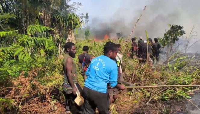 
					Warga di sekitar Ilaga berusaha memadamkan kobaran api. Foto: Diskominfo Puncak  