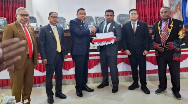 Bupati Kepulauan Yapen Benyamin Arisoy menyerahkan dokumen Raperda Perubahan APBD 2026 kepada Ketua DPRK Kepulauan Yapen Ebzon Sembai dalam Rapat Paripurna III. (KabarPapua.co/Ainun Faathirjal)