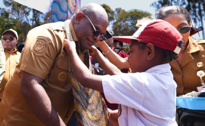 
					Gubernur Papua Tengah, Meki Nawipa saat dikalungi noken oleh siswa di Sugapa, Kabupaten Intan Jaya. Foto: Aberth You