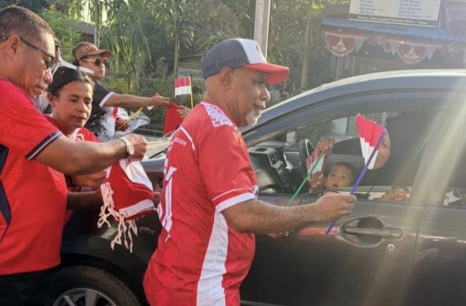 
					Saat Wagub Papua Tengah Deinas Geley bagikan bendera Merah Putih kepada para pengendara di jalan. (papuatengahprov.go.id)