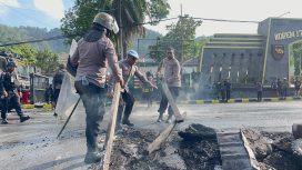 Pembersihan sisa pembakaran ban yang dilakukan oleh pendemo dari kampus USTJ. Foto: Humas Polresta Jayapura Kota
