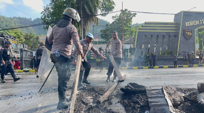 Pembersihan sisa pembakaran ban yang dilakukan oleh pendemo dari kampus USTJ. Foto: Humas Polresta Jayapura Kota