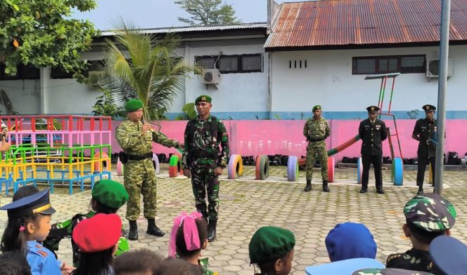 
					Prajurit Yonif TP 909 KRP memperkenalkan pakaian dinas dan perlengkapan TNI AD kepada anak-anak TK Pertiwi IV Serui. (Foto dok: IST)