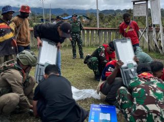 Pemasangan lampu panel surya di Arinop Pegunungan Bintang. Foto: Satgas Damai Cartenz